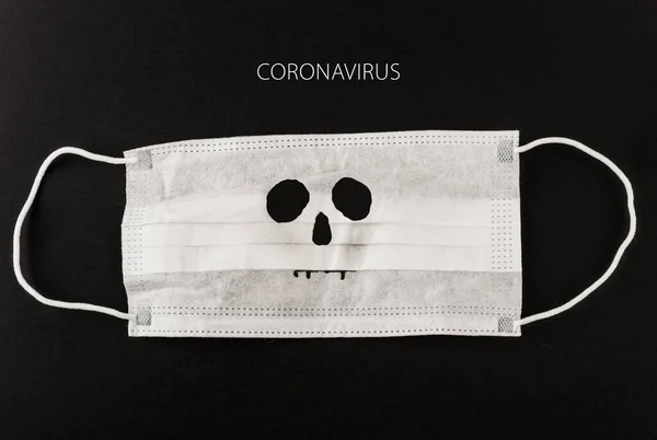 Siyah arka planda Coronavirus yazı ve kafatası ile tıbbi koruyucu maske. Cerrahi maske. Çin coronavirüs salgını kavramı.