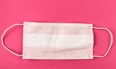 Pembe arka planda tıbbi koruyucu maske. Cerrahi maske. Çin coronavirüs salgını kavramı.