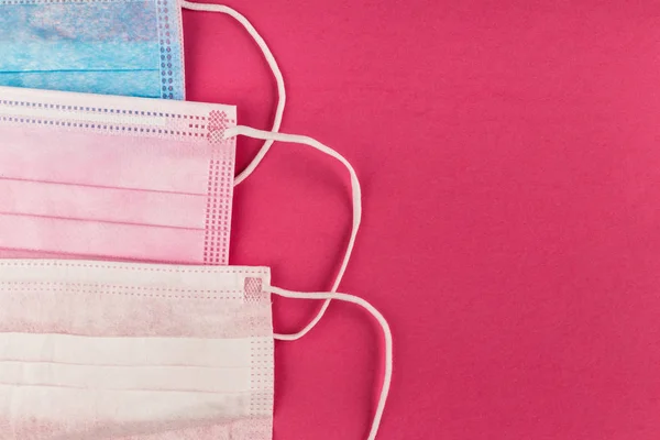 Medical protective masks on pink background. Surgical face mask. Chinese coronavirus outbreak concept.