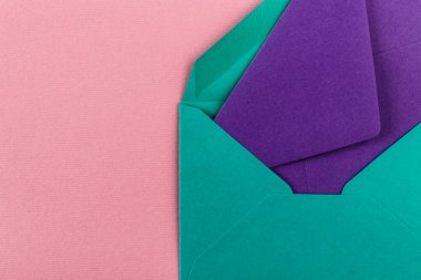 Pembe arka planda renkli zarflar. Posta zarfları masanın üstünde..