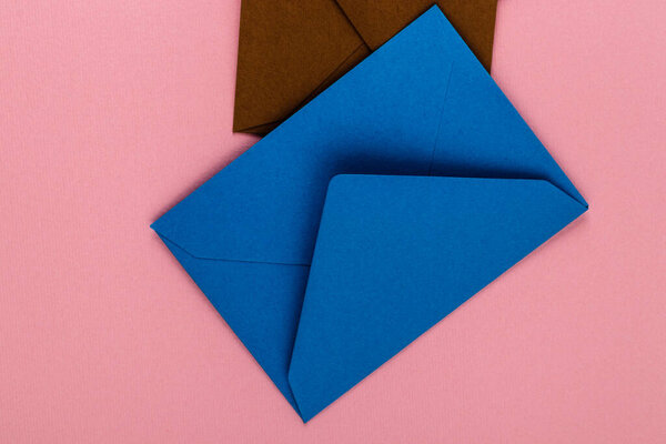 Colorful envelopes on a pink background. Mail envelopes on the table.