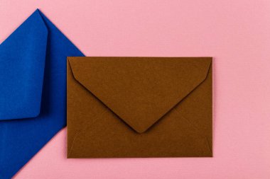 Pembe arka planda renkli zarflar. Posta zarfları masanın üstünde..