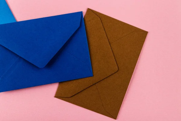 粉色背景上的彩色信封 桌上的邮包 — 图库照片