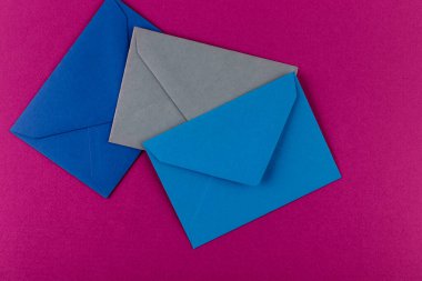 Mor arka planda renkli zarflar. Posta zarfları masanın üstünde..
