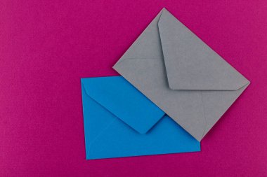 Mor arka planda renkli zarflar. Posta zarfları masanın üstünde..