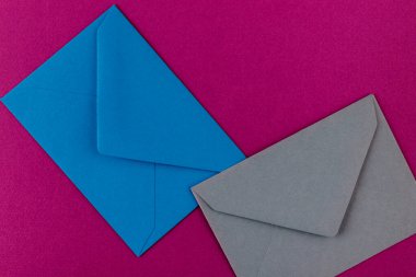 Mor arka planda renkli zarflar. Posta zarfları masanın üstünde..