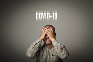 Hüsrana uğramış adam ve Covid-19. Adam Coronavirus için endişeleniyor. COVID-19 krizi ve Karantina kavramı.