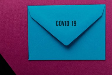 Mor arka planda renkli bir zarf. Covid-19 'dan dünyaya bir mesaj. COVID-19 krizi ve Karantina kavramı. 