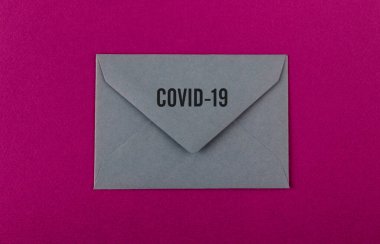 Mor arka planda renkli bir zarf. Covid-19 'dan dünyaya bir mesaj. COVID-19 krizi ve Karantina kavramı. 