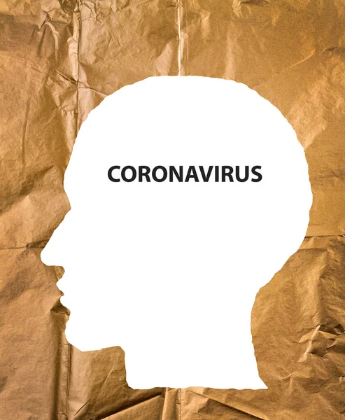 Crumpled paper human head with Coronavirus text. COVID-19 crisis concept. Virus everywhere.