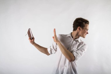 Çalışma kitabını elinde tutan genç bir adam. Gözlüklü adam. Konsepti sevme ve reddetme.