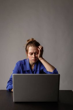 Mavili genç kadın internete bakmak için dizüstü bilgisayar kullanıyor..