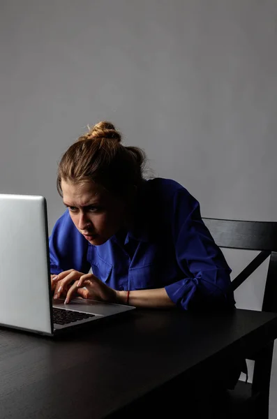 穿蓝色衣服的年轻女人用笔记本电脑上网 — 图库照片