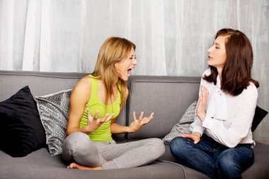 Anne ve kızı koltukta oturan.