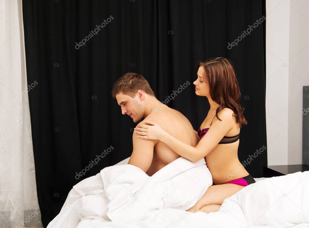 Unhappy young couple in bedroom.