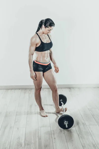 Sportliche athletische Frau hebt schwere Langhanteln in leichtem, geräumigem Raum — Stockfoto