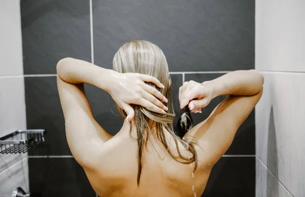 Mulher aplicando condicionador de cabelo . — Fotografia de Stock