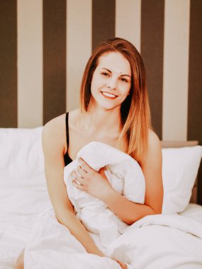 Yatakta genç ve güzel bir kadın.