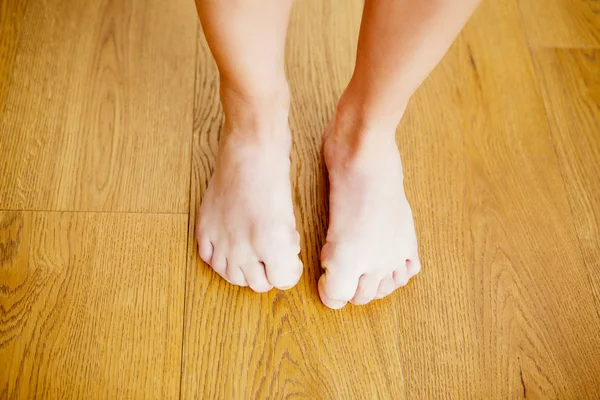 Womens feet on wooden floor. — Stock Photo, Image