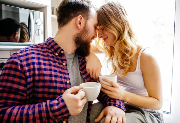 Giovane coppia sta bevendo tè e caffè a casa — Foto Stock