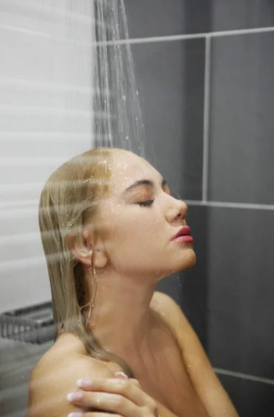 美しい裸の若い女性が浴室でシャワーを浴びて — ストック写真