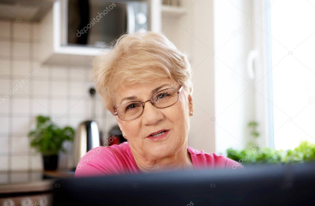 The senior lady surfing the internet with laptop computer