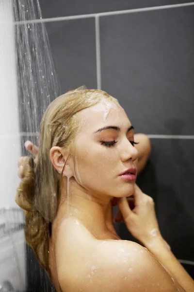 Mooie naakte jonge vrouw nemen douche in de badkamer — Stockfoto