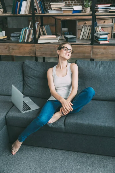 Mulher no sofá com laptop — Fotografia de Stock