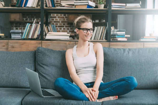 Mulher no sofá com laptop — Fotografia de Stock