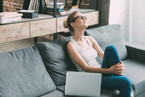 Mujer en sofá con portátil — Foto de Stock