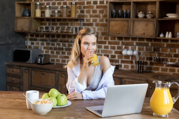 Mulher beber suco durante o café da manhã — Fotografia de Stock