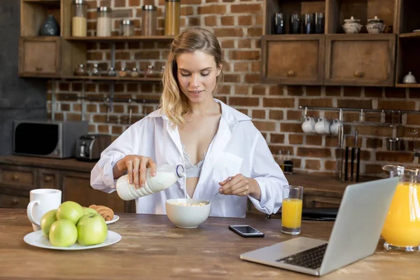 Mulher tomando café da manhã na cozinha — Fotografia de Stock