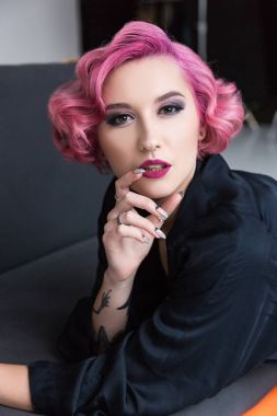 güzel, pembe saçlı PIN kızı koltukta poz