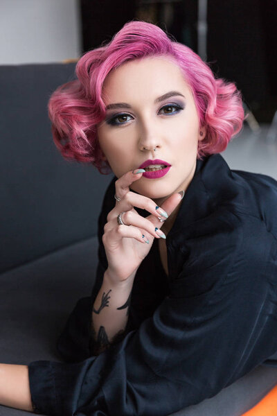 pretty pink haired pin up girl posing on couch