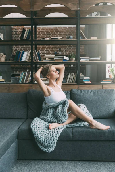 Jeune femme sur canapé — Photo de stock