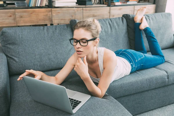 Mulher no sofá com laptop — Fotografia de Stock