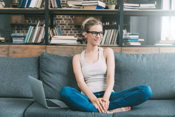 Woman on sofa with laptop — Stock Photo