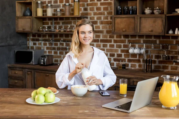 Mulher tomando café da manhã na cozinha — Fotografia de Stock