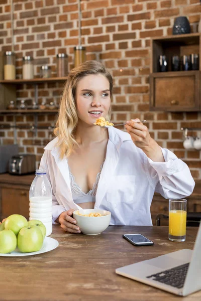 Woman having breakfast in kitchen — Stock Photo