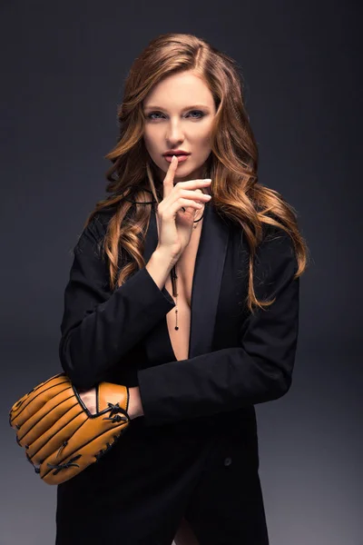 Mujer seductora con guante de béisbol mostrando señal de silencio - foto de stock