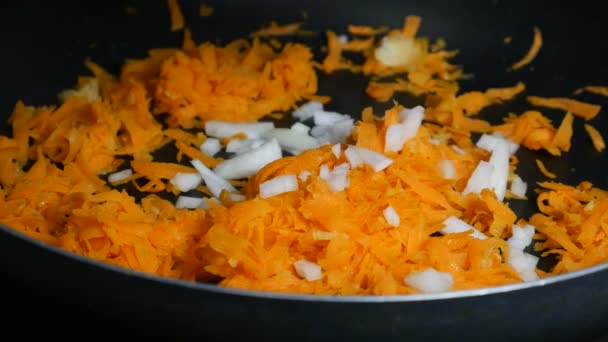 Добавить лук в морковь на сковороду — стоковое видео