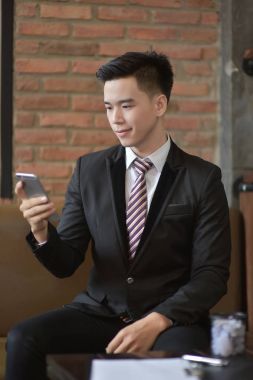 Mutlu işadamı, onun kanepede otururken cep telefonu kullanarak 