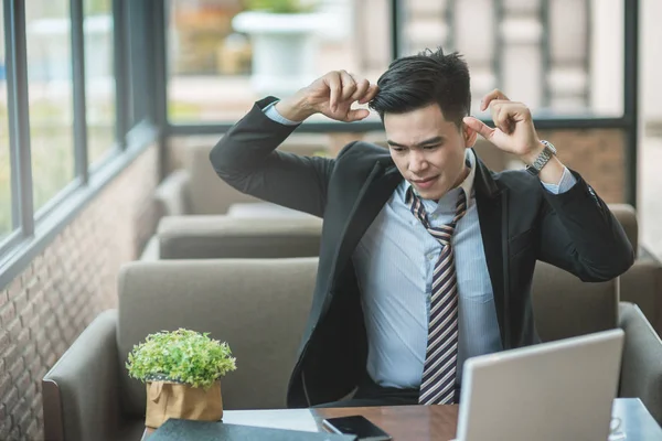 Angry senior businessman sitting at his desk and screaming, Angr