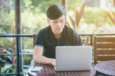 Evinde kanepede otururken Smartphone kullanarak çekici iş adamı. Mobil cihazlar çalışan genç insanlar kavramı. Seçili bir odak portre. Arka plan bulanık. 