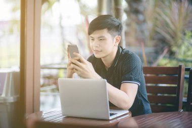 Evinde kanepede otururken Smartphone kullanarak çekici iş adamı. Mobil cihazlar çalışan genç insanlar kavramı. Seçili bir odak portre. Arka plan bulanık. 