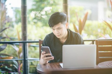 Evinde kanepede otururken Smartphone kullanarak çekici iş adamı. Mobil cihazlar çalışan genç insanlar kavramı. Seçili bir odak portre. Arka plan bulanık. 