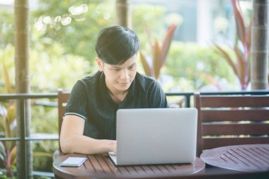 Evinde kanepede otururken Smartphone kullanarak çekici iş adamı. Mobil cihazlar çalışan genç insanlar kavramı. Seçili bir odak portre. Arka plan bulanık. 