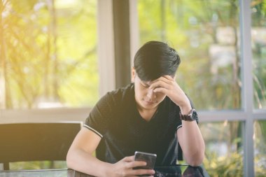 Evinde kanepede otururken Smartphone kullanarak çekici iş adamı. Mobil cihazlar çalışan genç insanlar kavramı. Seçili bir odak portre. Arka plan bulanık. 