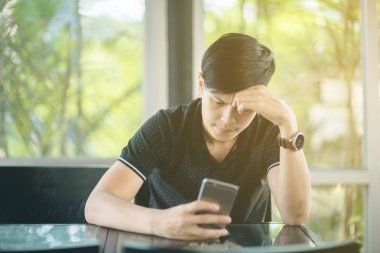 Evinde kanepede otururken Smartphone kullanarak çekici iş adamı. Mobil cihazlar çalışan genç insanlar kavramı. Seçili bir odak portre. Arka plan bulanık. 