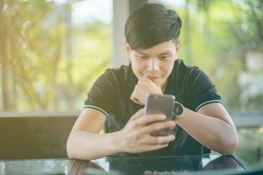 Evinde kanepede otururken Smartphone kullanarak çekici iş adamı. Mobil cihazlar çalışan genç insanlar kavramı. Seçili bir odak portre. Arka plan bulanık. 